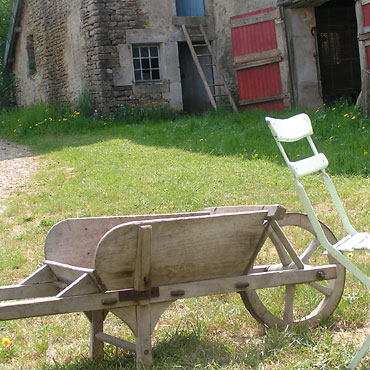 à la ferme : la brouette et une chaise de jardin devant la chambre à four