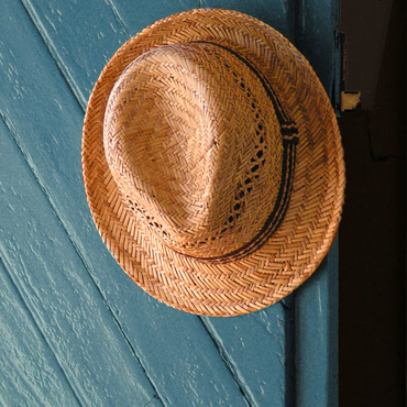 chapeau de paille accroché à la poignée de la porte d'entrée
